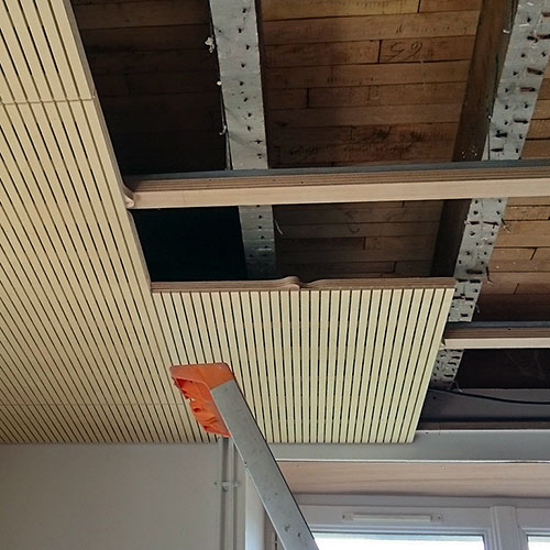 Fixation par suspentes et rail parachevé d’une lisse bois