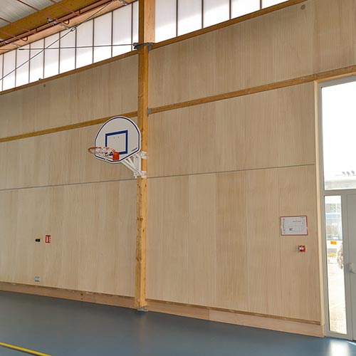 Panneaux acoustiques bois rainurés ab pano 50 aux murs d'une salle de sport