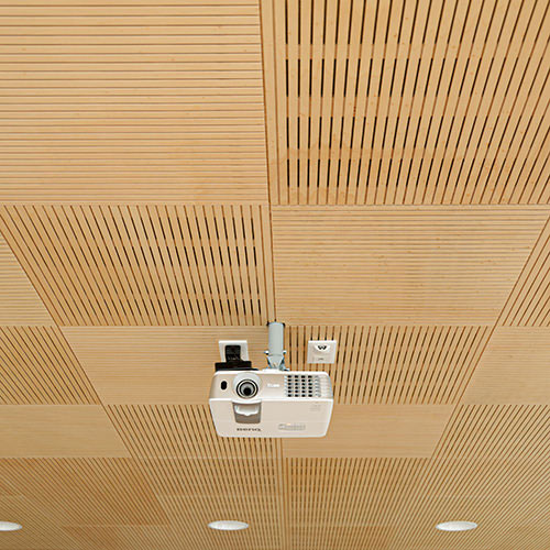 Panneaux acoustiques bois rainurés ab pano 25 au plafond d'une salle de réunion