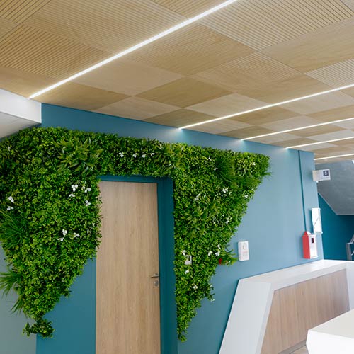 Panneau acoustique en bois rainuré ab pano 25 au plafond d'une maison de santé